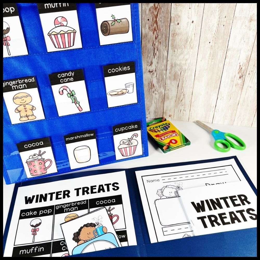Winter treats word cards like cookies, cocoa and candy cane in a blue pocket chart beside a writing folder